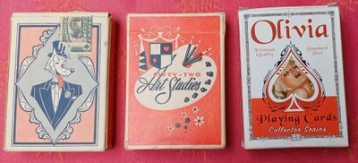 trois cartes à jouer vintage sont alignées sur un fond rose