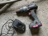 a corded drill and a charger on the floor