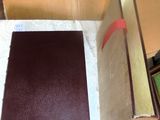 a brown book sitting on top of a table next to a box