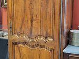 une armoire en bois dans une pièce où se trouve un miroir accroché au mur