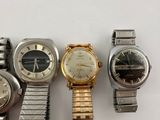 several watches are lined up in a row on a white surface