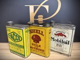 three cans of shell oil are sitting on a table next to a sign