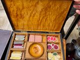une personne tenant une boîte en bois contenant de nombreux objets