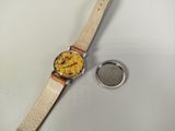 a watch that is sitting on a table next to a coin