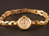 an image of a woman ' s wrist watch on a black surface
