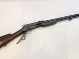 a rifle with a wooden barrel on a white surface