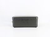 an old black metal box sitting on top of a white surface