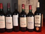 several bottles of red wine are lined up on a table