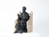 a statue of a man sitting on a chair