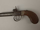 an old gun with a wooden handle on a white surface