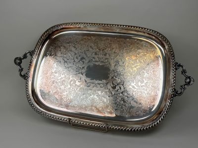 plateau de service plaqué argent avec des poignées, sur un fond gris