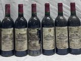 several bottles of wine are lined up in a row on a table
