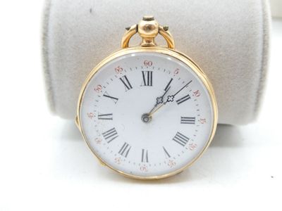 a small gold pocket watch with roman numerals on it