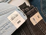 a lot of jeans on a table with a price tag on them