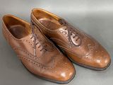 pair of men ' s brown leather shoes with laces on them