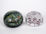 two glass paperweightes sitting next to each other on a white surface