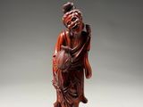an old wooden statue of a man holding a fish