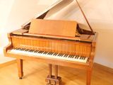 a grand piano sitting in a room with a wooden floor