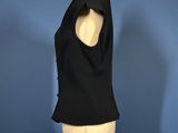 a black top on a mannequin stand against a blue background