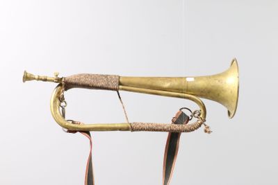 a brass trumpet that is hanging on a wall