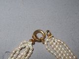 a close up of a necklace with pearls on it