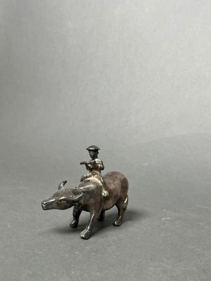 figurine of a man riding a boar with a bird on its back