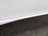 a close up of a white car with rust on the side of it