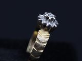 a close up of a gold and diamond ring on a black surface
