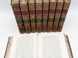 six old books are stacked on top of each other on a table