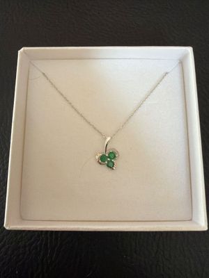 a white box with a green clover pendant on it