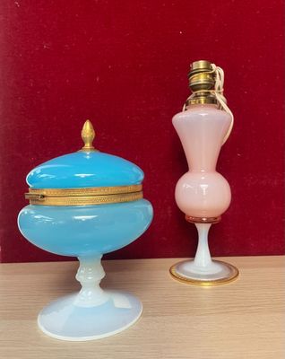 two vases sitting on a table with a red wall in the background