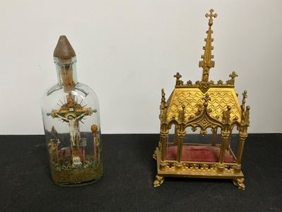 deux bouteilles en verre ornées de motifs dorés, posées sur une table