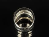 an image of a silver ring on a black surface