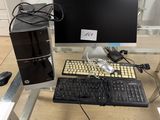 un ordinateur de bureau et un clavier posés sur une table en verre