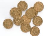 some gold coins are scattered on a white surface with a white background