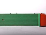 a green box with a red handle sitting on a white surface