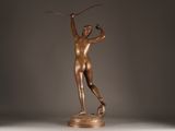 bronze statue of a female athlete holding a pole in her right hand