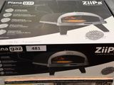 packaging of a pizza oven sitting on top of a cardboard box