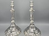 pair of antique silver candlesticks on pedestal on grey background