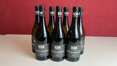 quatre bouteilles de vin sont alignées sur une table