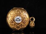 a gold locke with a diamond in it on a black surface