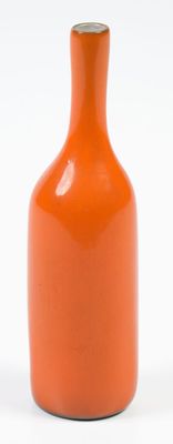 an orange vase that is sitting on a white surface