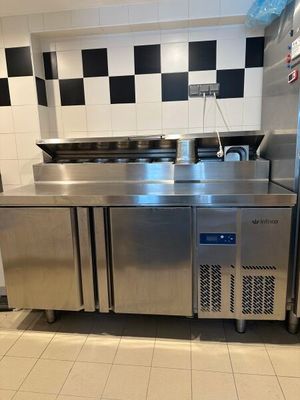 une grande cuisine en inox avec une crédence à carreaux