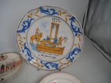 a plate with a painting on it next to a plate with a painting on it