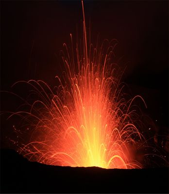une image d'un volcan crachant de la lave dans les airs, la nuit