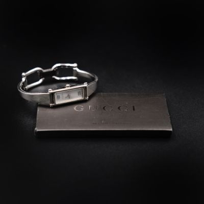 a close up of a silver bracelet with a tag on it