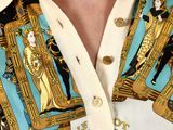 a man wearing a shirt with a gold and blue design on it
