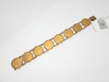 un gros plan d'un bracelet orné de pièces d'or