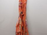 an orange dress hanging on a white wall in a room