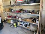 une voiture garée dans un garage, à côté d'une étagère remplie d'outils